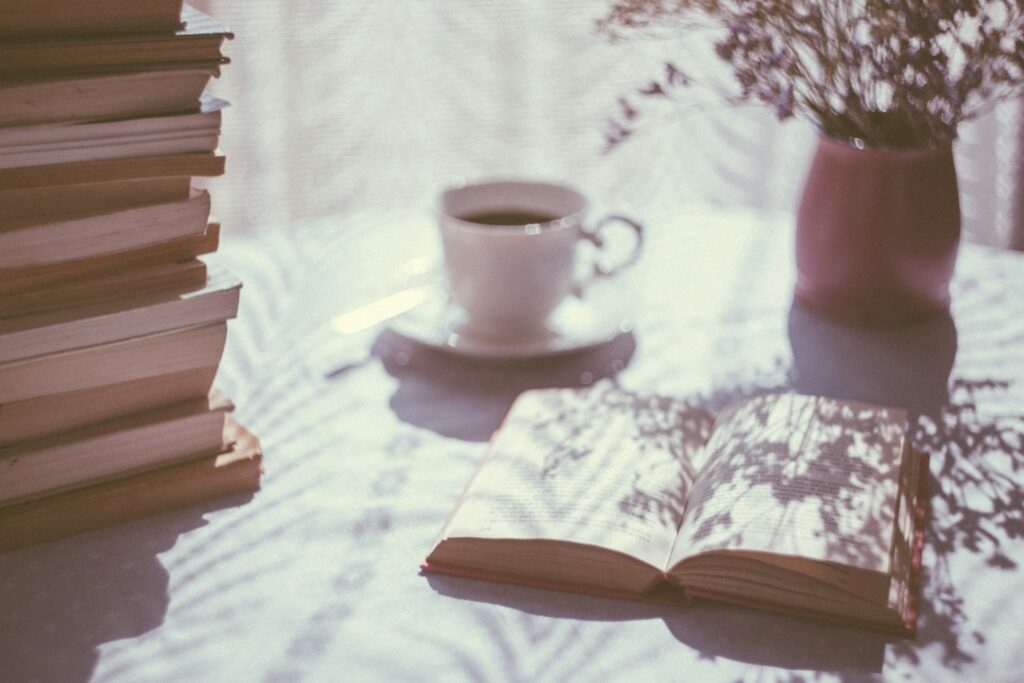 open book with a white cup on a saucer