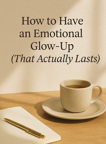 A beige coffee cup on a saucer sits beside a notebook and pen on a wooden table. The background features the text: How to Have an Emotional Glow-Up (That Actually Lasts).