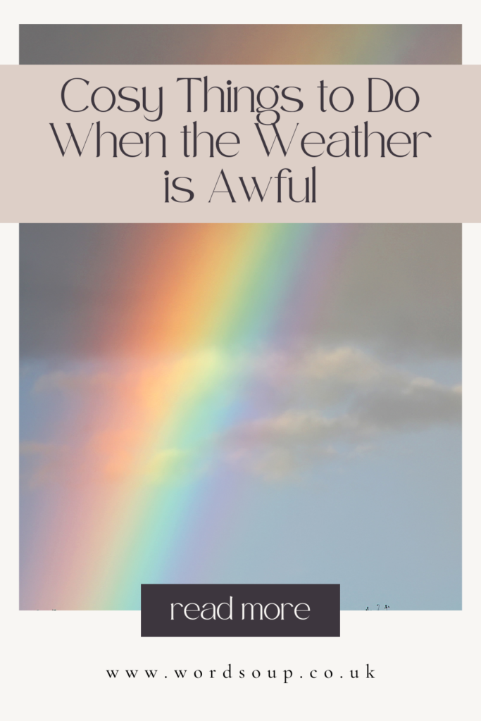 A bright rainbow in a cloudy sky with text: Cosy Things to Do When the Weather is Awful. Read more. www.wordsoup.co.uk.