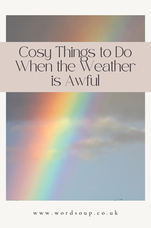 A rainbow in a cloudy sky with text overlay: Cosy Things to Do When the Weather is Awful. Website link www.wordsoup.co.uk appears at the bottom.