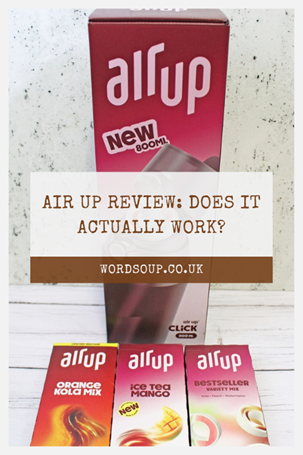 Box of Air Up drinking system with three flavoured pod packs (orange cola, iced tea mango, and bestseller mix) on a white surface. Overlaid text: Air Up Review: Does It Actually Work? wordsoup.co.uk.