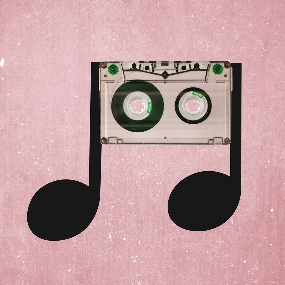 A clear cassette tape is placed above two black musical notes on a pink textured background, making the tape appear as part of the notes.